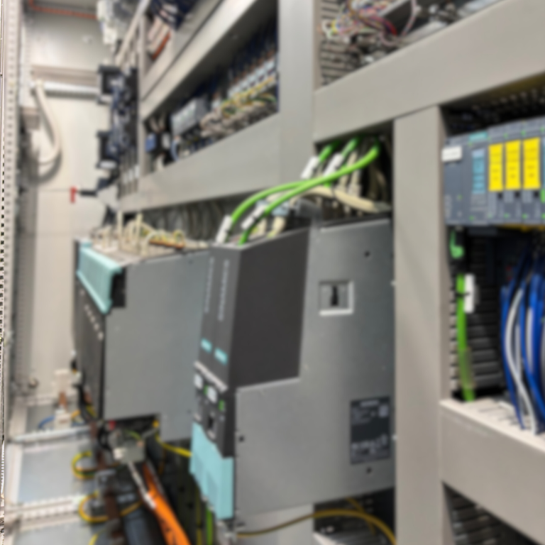 Detailansicht eines komplexen Maschinenbauteils/ Elektromotor mit bunten Kabeln und Metallgittern.